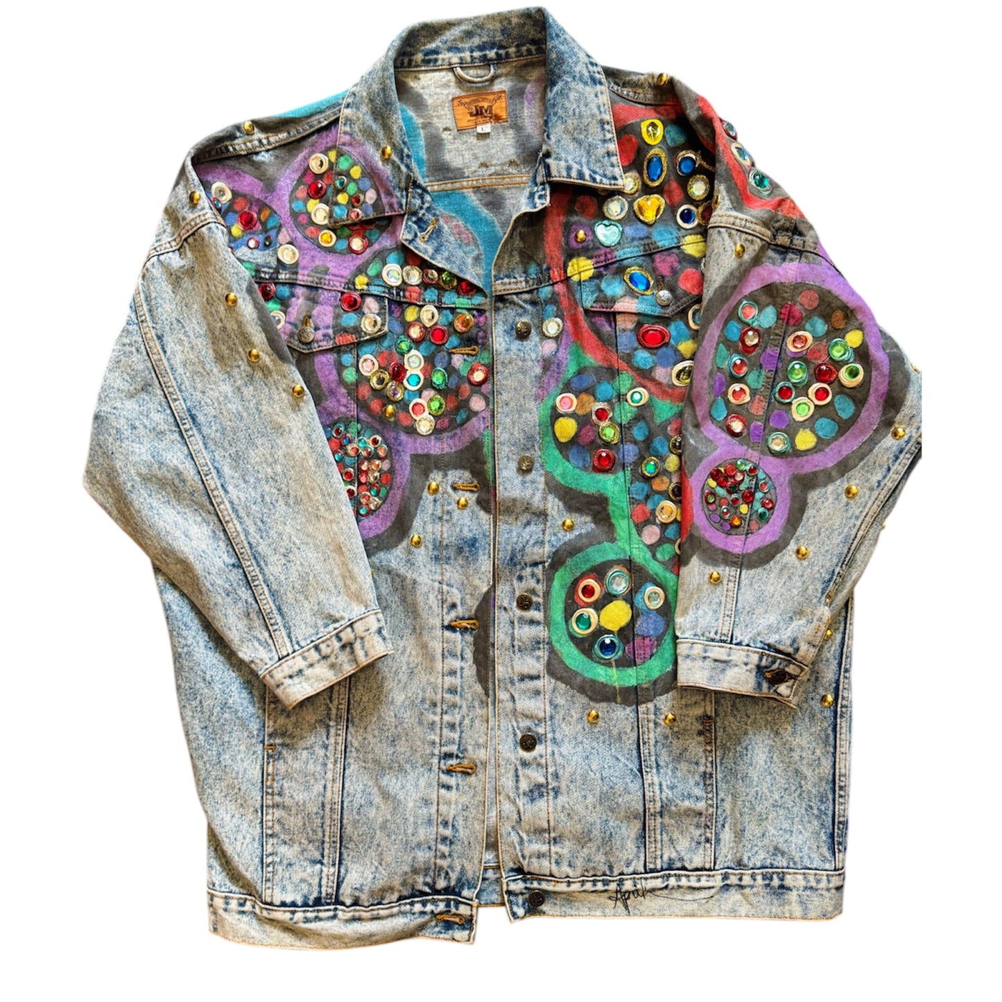 A bedazzled denim jacket with multicolored geometric patterns and decorative elements.