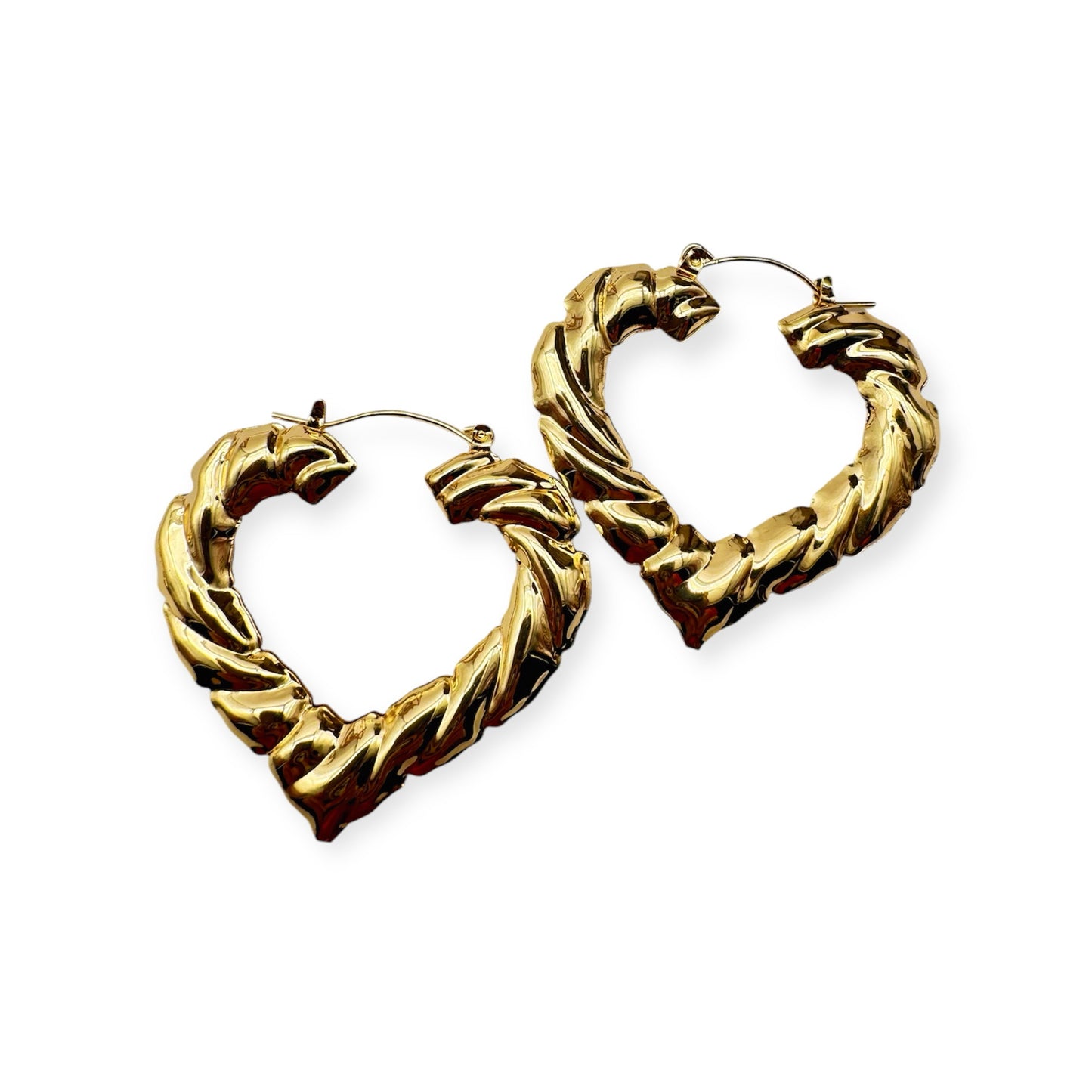 A pair of vintage gold hoop earrings with a textured surface. Gold heart-shaped rope earrings by Everythang Dope, bold retro jewelry.