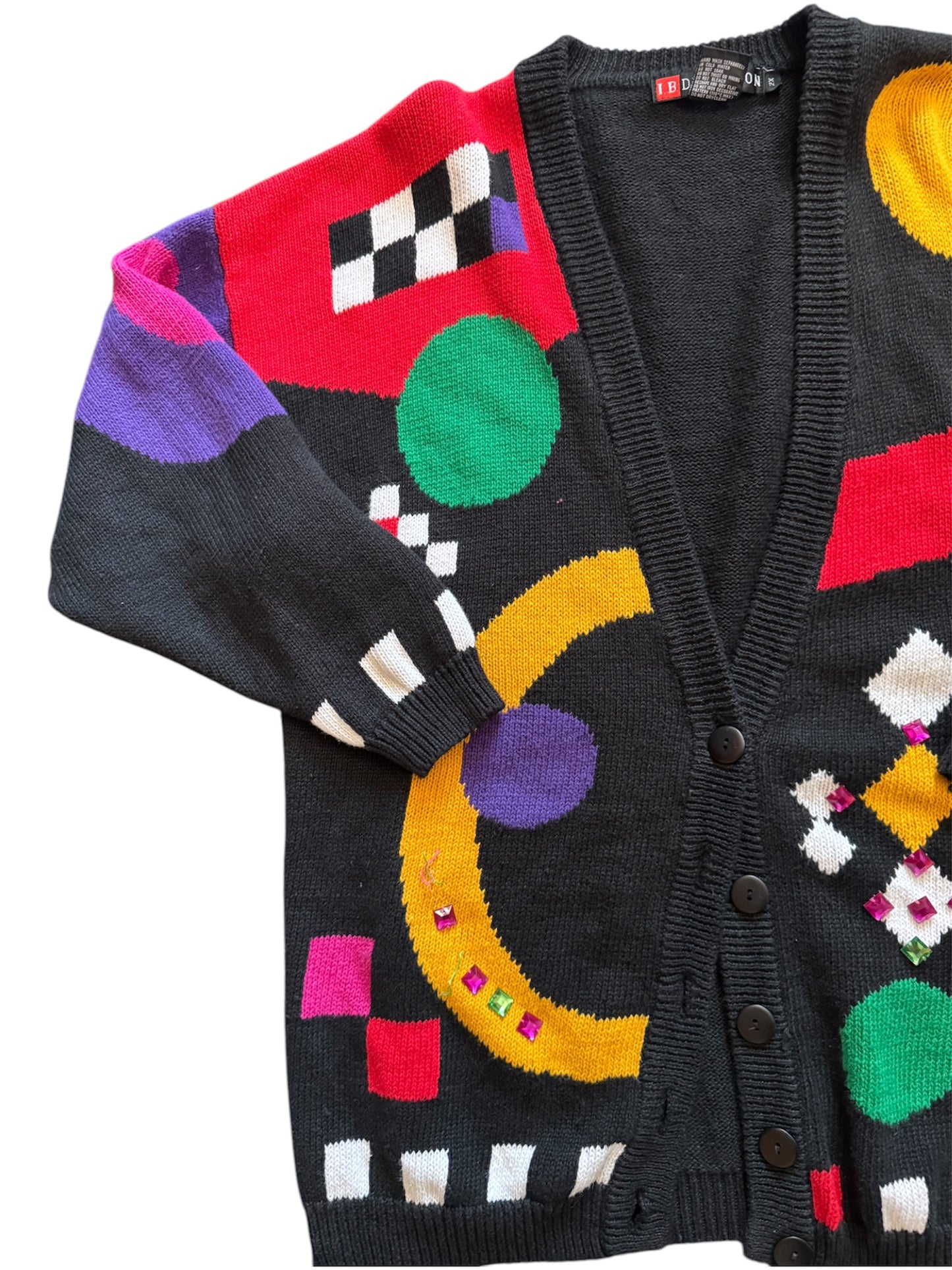 Multi-color vintage cardigan with checkerboard green and yellow circle patterns, bold 90s fashion.