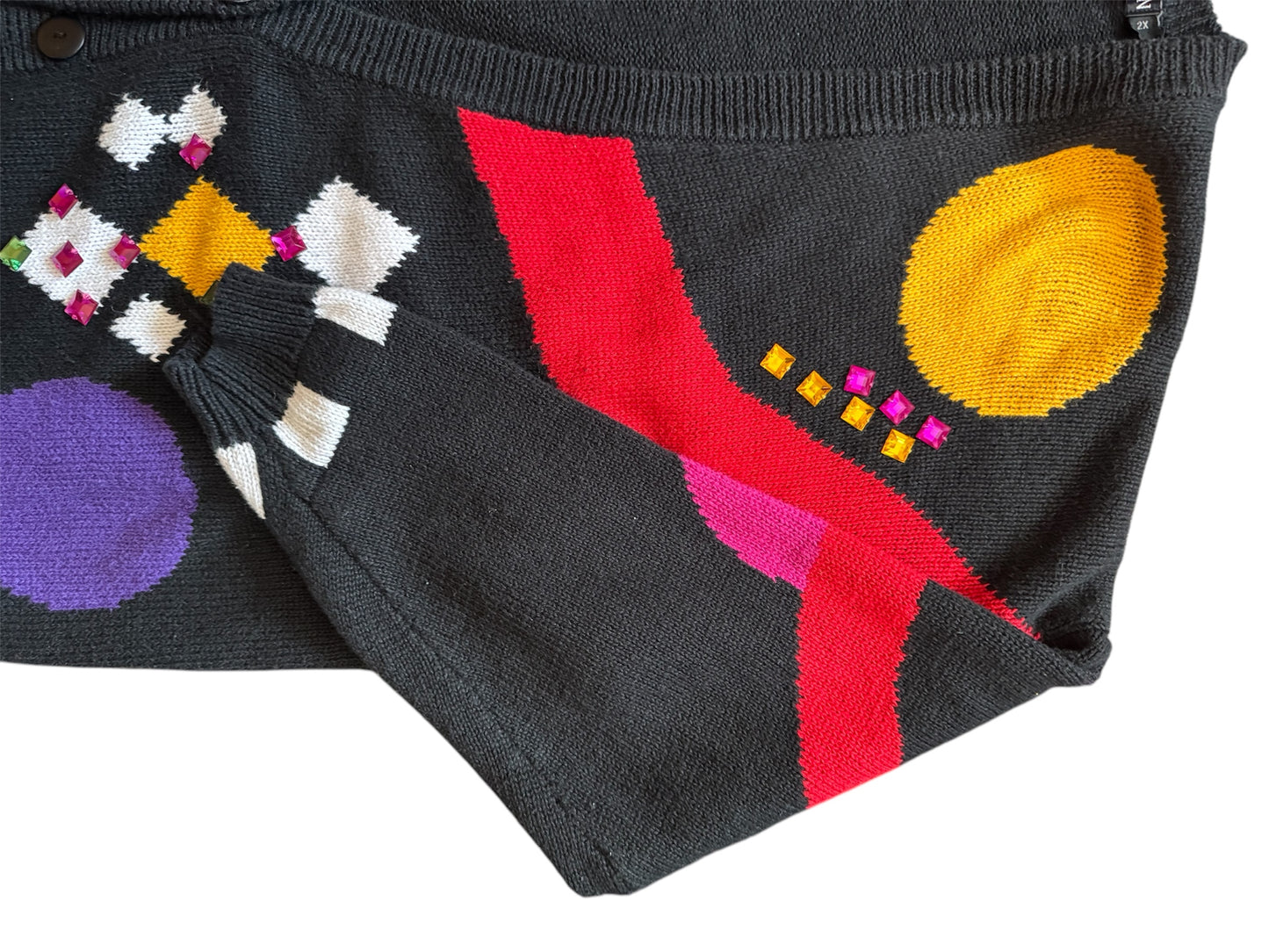 Multi-color vintage cardigan with checkerboard green and yellow circle patterns, bold 90s fashion.