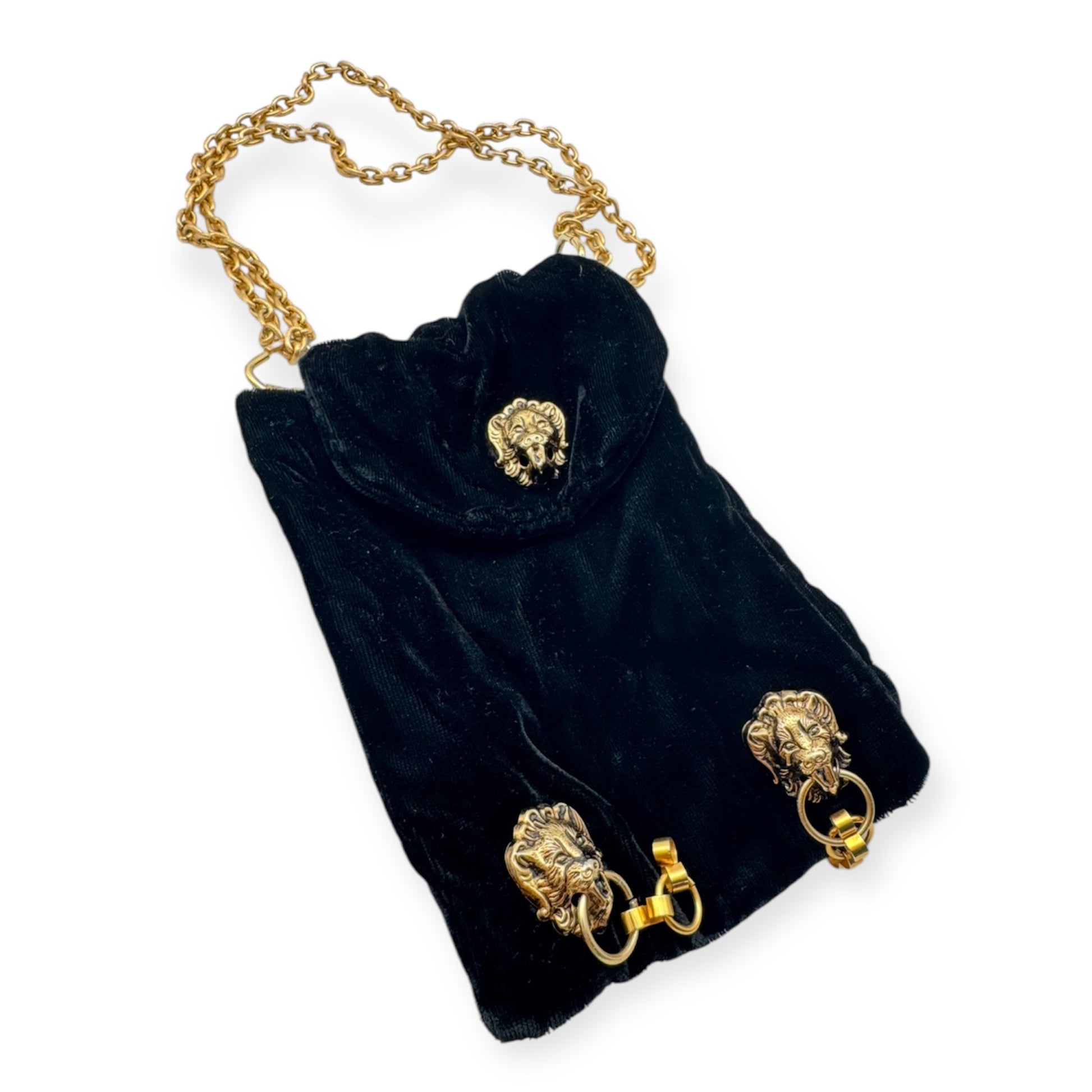 A vintage black velvet cocktail bag with gold chain strap and lion head decorations.